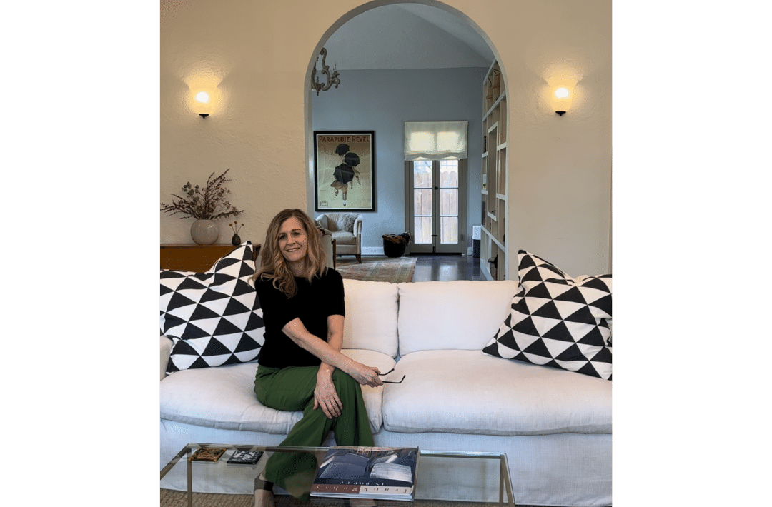 Karen Hittelman, founder of Grab Your Happy, sitting on a white sofa with big throw pillows